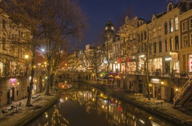 Utrecht, Hollanda, 21 Ocak 2019: Kanal evleri, wharfs, ağaçlar ve şehir ışıkları eski Canal ayna gibi suda mavi saat içinde bir kış gecesi yansıtacak.