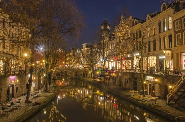 Utrecht, Hollanda, 21 Ocak 2019: Kanal evleri, wharfs, ağaçlar ve şehir ışıkları eski Canal ayna gibi suda mavi saat içinde bir kış gecesi yansıtacak.