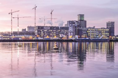 Rotterdam, Hollanda, 18 Ocak 2019: Katendrecht grainsilo Rijnhaven Limanı ayna gibi suda güneş doğarken yansıtır.