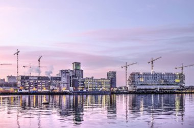 Rotterdam, Hollanda, 18 Ocak 2019: Grainsilo Katendrecht en yeni Fenixlofts konut yapı yansıtmak Rijnhaven içinde güneş doğarken liman