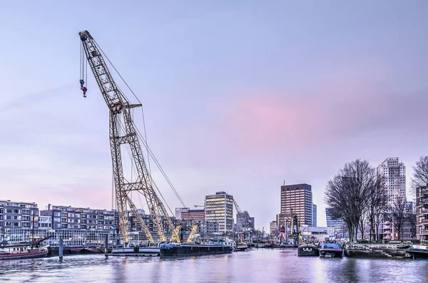 Rotterdam, Hollanda, 13 Şubat 2019: Leuvehaven Müzesi liman mor bir günbatımı gökyüzü altında ön planda bir yüzen Derrick ile