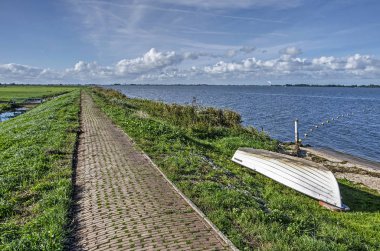Göl Gouwzee Marken ada, mavi gökyüzü altında Hollanda Tarih boyunca düşük çimenli nehir üzerinde dar tuğla yolu