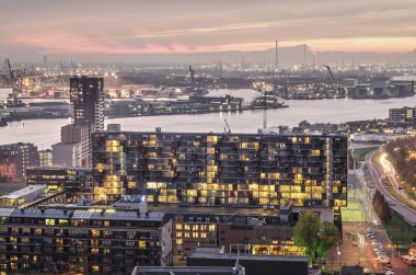 Rotterdam, Hollanda, Kasım 12, 2019: akşam Lloydkwartier sahil geliştirme, nehir ve liman ile arka planda modern konutlar üzerinde düşüyor