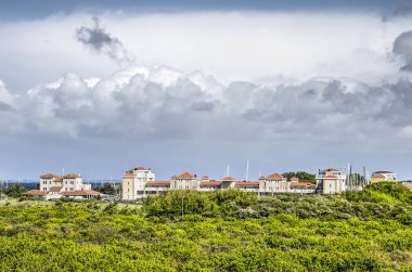 Brouwersdam, 4 Mayıs 2019: Dramatik bulutlar ve yemyeşil kumul manzara arasında Port Zelande tatil beldesi biraz yüksek görünümü