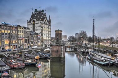 Rotterdam, Hollanda, 22 Aralık 2016: Tarihi gökdelen Ii Beyaz Saray'a doğru tarihi mavnalarıyla Wijnhaven limanının karşısına bak, gün batımında