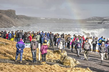 Gulfoss, İzlanda, 27 Şubat 2019: gökkuşağı yla süslenmiş ünlü şelaleye bakan turist kalabalığı