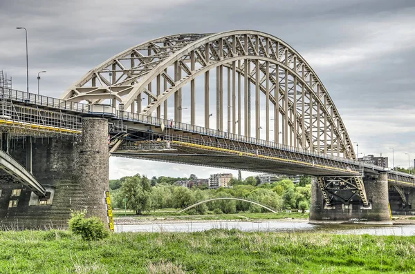 ナイメーヘン オランダ 2019年4月25日 川ワル川を渡る古い鋼鉄アーチ橋 修理で 背景に 近代的な歩行者アーチ橋Ooypoort — ストック写真