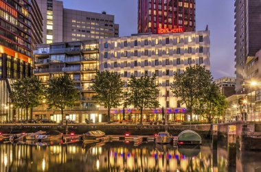 Rotterdam, Hollanda, 21 Mayıs 2019: Sloop marina, Ibis otel ve konut highrise ile Wijnhaven limanıiskelemavi saat görünümü