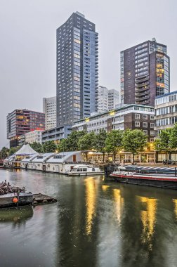 Rotterdam, Hollanda, 20 Mayıs 2019: Gün batımında modern konut kuleleri ile Wijnhaven limanı ve Wijnhaven adasının manzarası