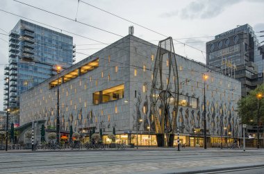 Rotterdam, Hollanda, 7 Mayıs 2019: Yenilenmiş Naum Gabo scultpure ve Bijenkorf alışveriş merkezi ile alacakaranlıkta Coolsingel bulvarı restore edilmiş orijinal aydınlatmaile