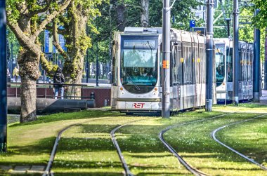 Rotterdam, Hollanda, 20 Mayıs 2018: iki tramvay şehir Westersingel kanal boyunca çim kaplı parçaları boyunca hareket ediyor