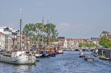 Leiden, Hollanda, 18 Mayıs 2019: Tarihi mavnalar ve evler, yatlar ve yüzen evler ile eski kente galgewater kanalı üzerinden Rembrandt köprüden görünümü