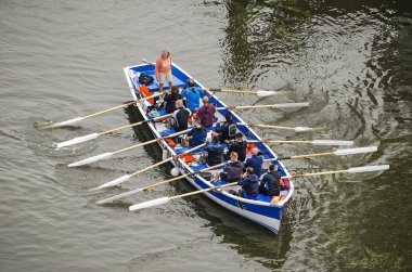 Rotterdam, Hollanda, 8 Eylül 2019: Wijnhaven limanında mavi beyaz bir sloop kürek bir grup erkek havadan görünümü