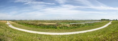 Yeni Reevediep nehir kanalı boyunca beton bir bisiklet yolu panoramik kompozit görünümü ve Kampen yakınlarındaki bitişik sulak alanlar, Hollanda cirrus bulutlar ile bir yaz gökyüzü altında