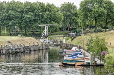 Vollenhove, Hollanda, 4 Ağustos 2019: küçük yatlar ve yelkenli tekneler ve ağaçlı eski limanda bir drwabridge