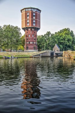 Zwolle; The Netherlands; July 25; 2019: the historic water tower, now converted to appartments, reflects in the adjacent Almelose canal clipart