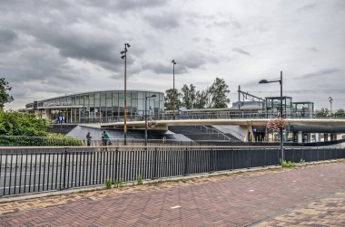 Helmond, Hollanda, 16 Ağustos 2019: bisiklet ler ve yayalar için bir köprü arka planda yeni tren istasyonu ile, istasyon meydanında yoğun bir yol geçer