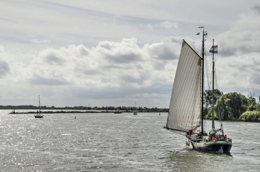 Medemblik, Hollanda, 13 Eylül 2019: Ijsselmeer Gölü'nde tarihi yelkenli tekne, yaz sonunda güneşli bir günde şehrin limanına yaklaşıyor