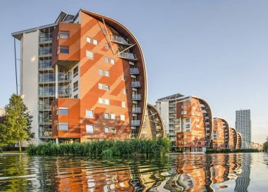 Den Bosch, Hollanda, 20 Eylül 2019: yaz sonunda güneşli bir günde altın saat içinde bitişik gölet yansıtan yelkenli ilham konut binaları, satır