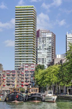 Rotterdam, Hollanda, 12 Ekim 2019: Bierhaven limanında tarihi gemiler, 1980 'lerden kalma konut binaları ile çevrili, arka planda daha yakın zamandaki apartman kuleleri bulunuyor.