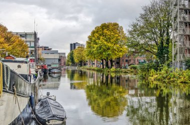 Rotterdam, Hollanda, 13 Kasım 2019: tekneler, iş yerleri, konut blokları ve sonbaharda bulutlu bir günde Buizengat Kanalı 'nda yansıyan renkli ağaçlar