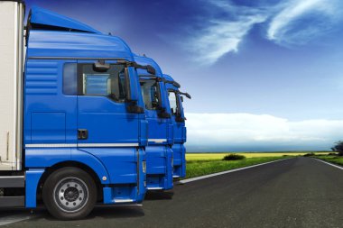 Perspektif zemin üzerine mavi gökyüzü ile yol boyunca üç kamyon