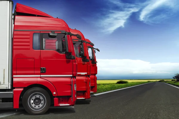 Yolda bir arka plan üzerinde kırmızı gökyüzü ile perspektif içinde üç kamyon