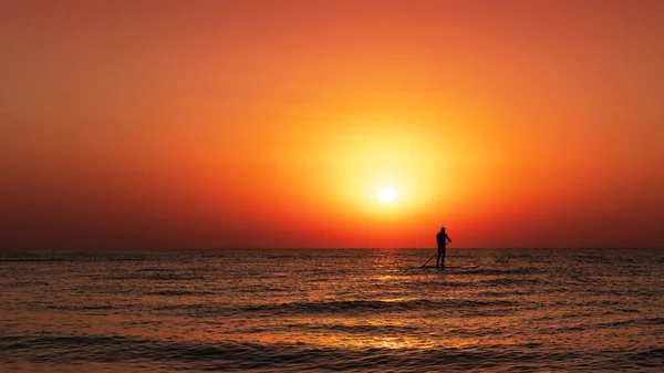Mann Auf Dem Wasserpaddelbrett Bei Goldenem Sonnenaufgang Horizontales Foto Stockbild