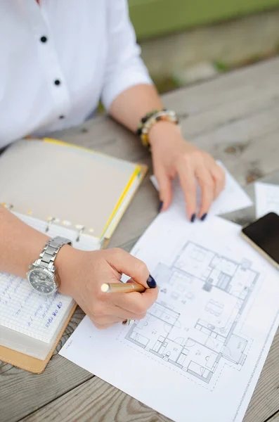 İş kadını elinde kalemle belge arıyor.