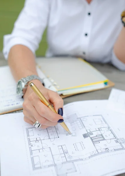 İş kadını elinde kalemle belge arıyor.