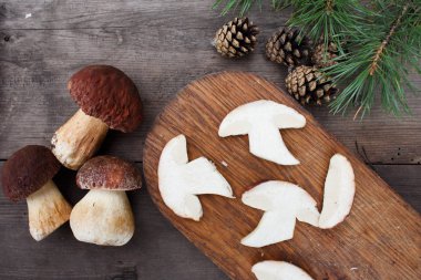 Boletus mantar eski ahşap masa, bütün ve bir kesme tahtası üzerinde dilimler halinde kesilmiş.