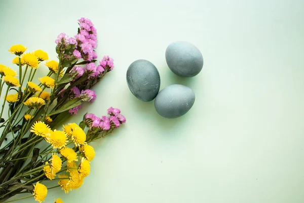 Painted eggs and a bouquet of spring flowers — Stock Photo, Image