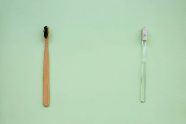 Two Toothbrushes Natural Bamboo Plastic Green Paper Background Concept Choice — Stock Photo, Image