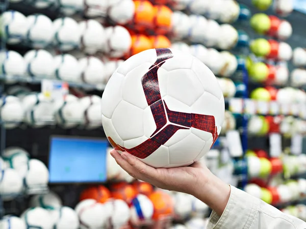 Χέρι με μπάλα ποδοσφαίρου στο αθλητικό κατάστημα — Φωτογραφία Αρχείου