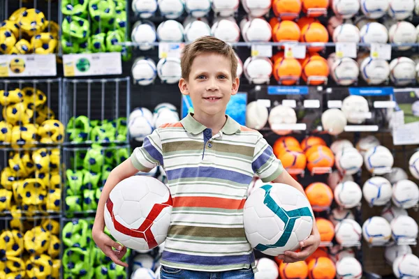 Menino com bolas de futebol na loja de desporto — Fotografia de Stock