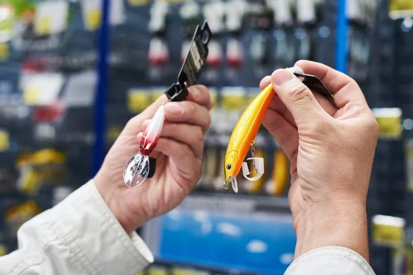 Cebo señuelo de pesca en las manos hombre en la tienda — Foto de Stock