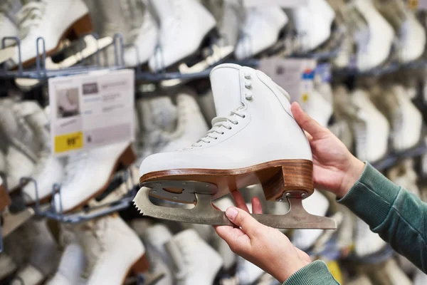 Руки жінки з фігурними ковзанами в спортивному магазині — стокове фото