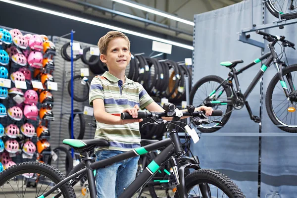 Chlapec a kolo ve sportovním obchodě — Stock fotografie