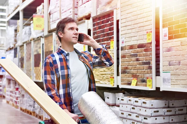 Homme Avec Smartphone Choisit Achète Des Marchandises Dans Supermarché Construction — Photo