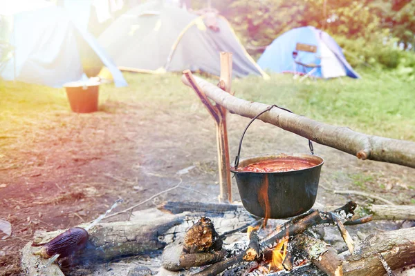 キャンプファイヤーと観光のテントにスープとボウラー — ストック写真