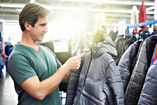 Мужчина Выбирает Зимнюю Куртку Магазине — стоковое фото