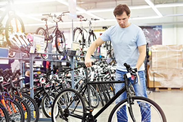 人在体育商店买自行车之前先要检查一下 — 图库照片
