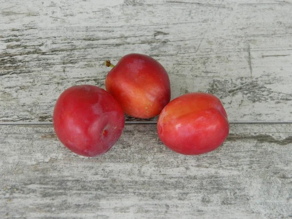 Plum Merah Pada Latar Belakang Kayu — Stok Foto