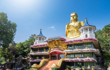 DAMBULLA, SRI LANKA - 10 Şubat 2017. Altın Tapınak Dambulla Budist Müzesi 'nin tepesindeki dev altın Buda heykeli. Kutsal yeri inananlar, turistler ve yerliler ziyaret ediyor.