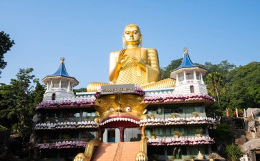 DAMBULLA, SRI LANKA - 10 Şubat 2017. Altın Tapınak Dambulla Budist Müzesi 'nin tepesindeki dev altın Buda heykeli. Kutsal yeri inananlar, turistler ve yerliler ziyaret ediyor.