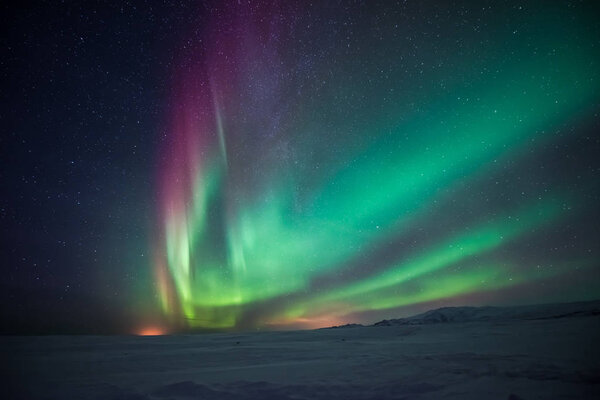 scenic shot of beautiful northern lights over snow valley