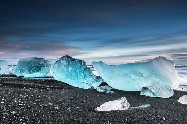 在北极落日的黑色沙滩上融化的冰川碎片的风景照片 — 图库照片