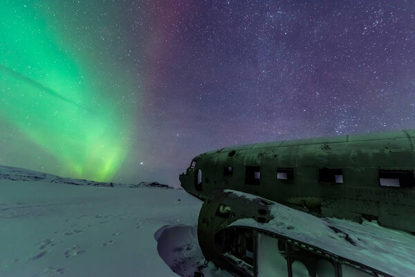 Северное сияние над крушением самолета в Вике, Исландия
