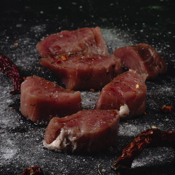 Rohes Schweinemedaillons Fleisch. frische Steaks auf schwarzem Hintergrund. 45 Grad — Stockfoto