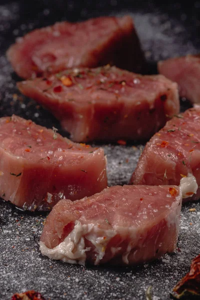 Rohes Schweinemedaillons Fleisch. frische Steaks auf schwarzem Hintergrund. 45 Grad — Stockfoto